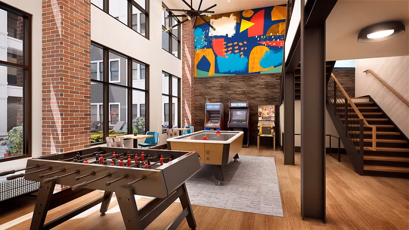 Vibrant game room with pool table and lounge seating at Union on Frank Apartments, perfect for socializing and relaxation