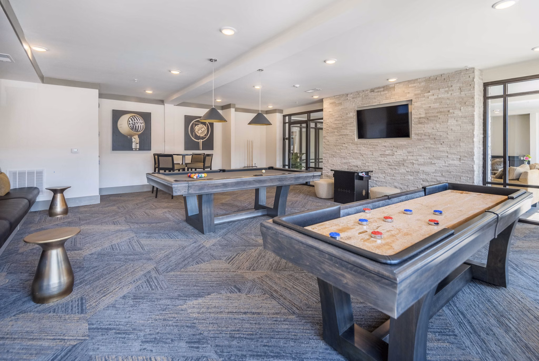 Vibrant game room featuring pool table and lounge seating in Leigh House Apartments