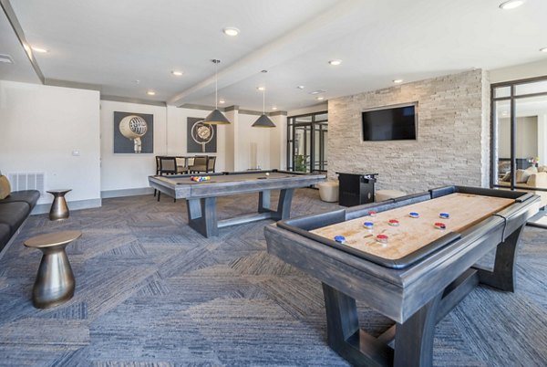 Vibrant game room featuring pool table and lounge seating in Leigh House Apartments