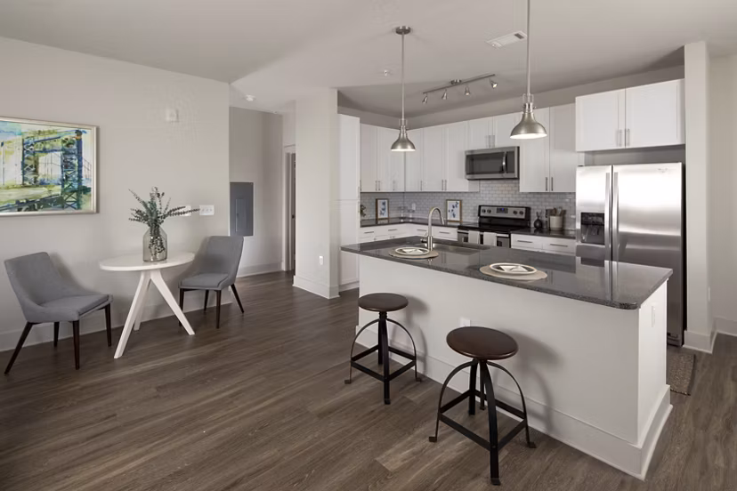 Modern kitchen featuring stainless steel appliances and granite countertops at Leigh House Apartments
