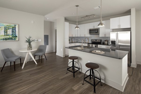 Modern kitchen featuring stainless steel appliances and granite countertops at Leigh House Apartments