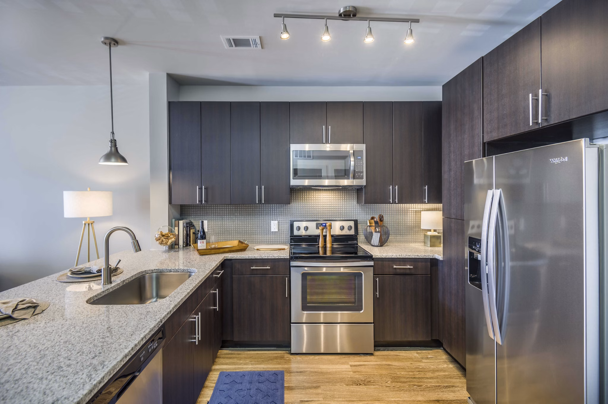 Modern kitchen with stainless steel appliances and granite countertops at Leigh House Apartments, luxury living in the heart of the city