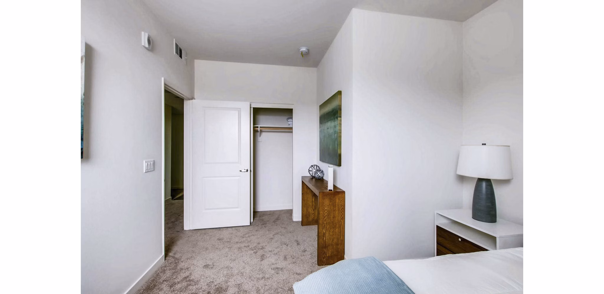 Cozy bedroom featuring modern decor and large windows at Ascent at Campus of Life Apartments in luxury Greystar community