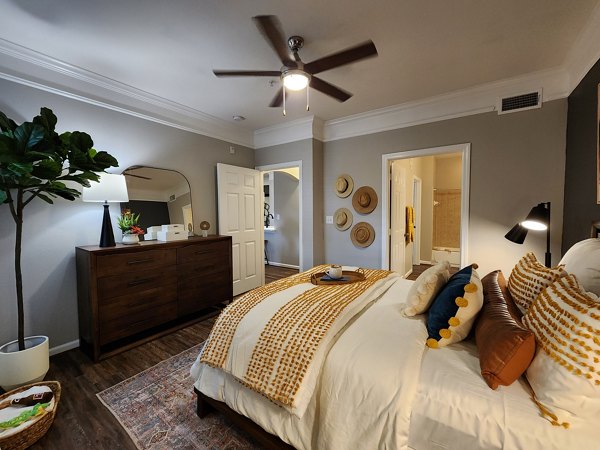 Bedroom featuring plush bedding and modern decor at Grand Villas at Tuscan Lakes Apartments