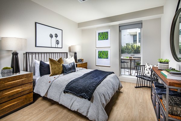 Cozy bedroom featuring plush bedding and modern decor at Llewellyn Apartments