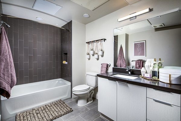 Bathroom featuring sleek fixtures and tile design at Llewellyn Apartments