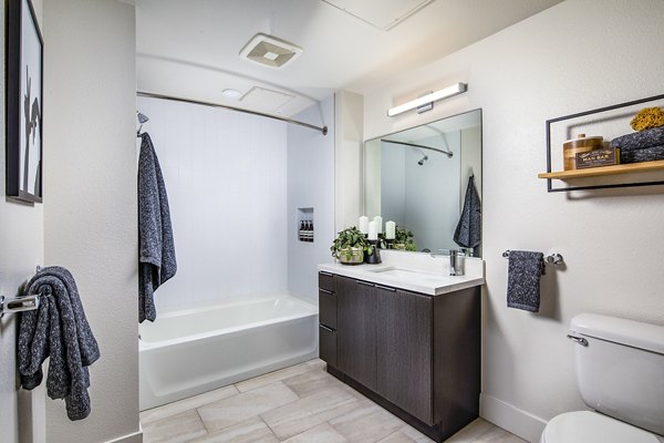Modern bathroom featuring sleek fixtures and ample lighting at Llewellyn Apartments