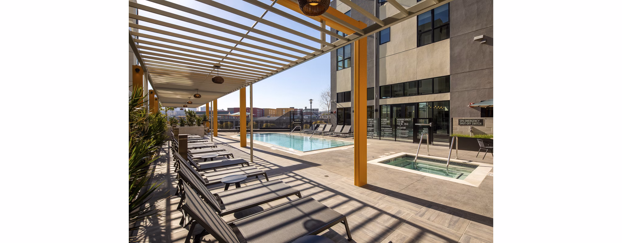 Resort-style pool at Llewellyn Apartments featuring relaxing lounge areas