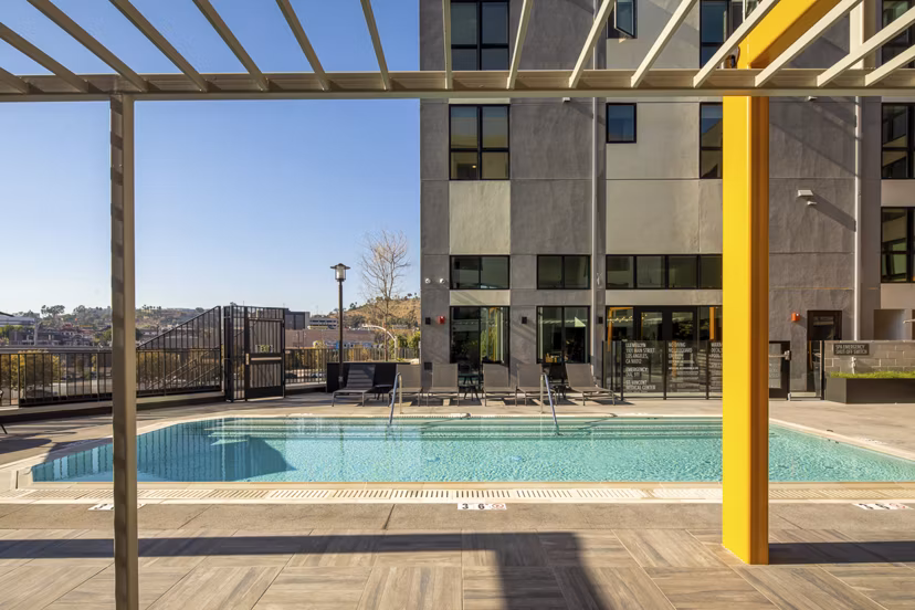 Outdoor pool area with lounge chairs at Llewellyn Apartments, perfect for relaxation and recreation for residents in luxury living
