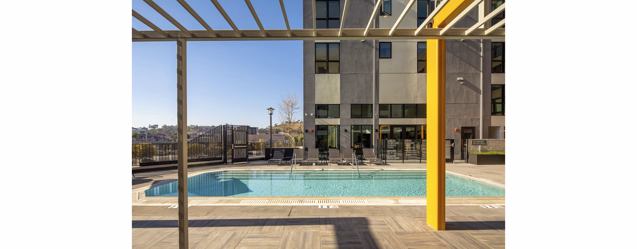 Outdoor pool area with lounge chairs at Llewellyn Apartments, perfect for relaxation and recreation for residents in luxury living