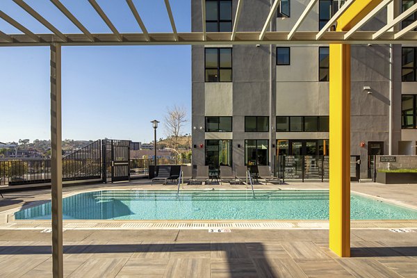 Outdoor pool area with lounge chairs at Llewellyn Apartments, perfect for relaxation and recreation for residents in luxury living