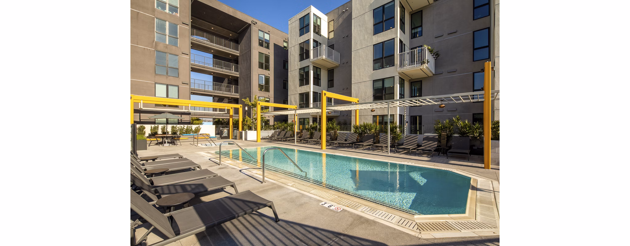 Relaxing pool area with lounge chairs at Llewellyn Apartments, luxury living by Greystar
