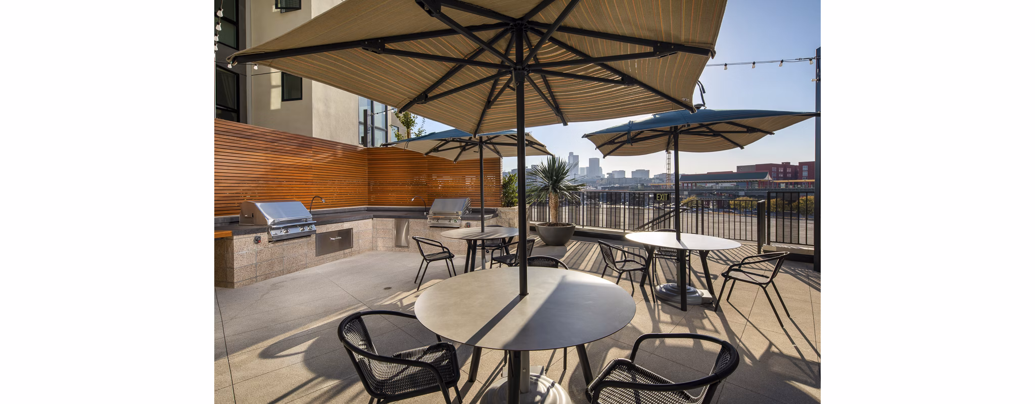 Grill area with modern picnic tables at Llewellyn Apartments' courtyard