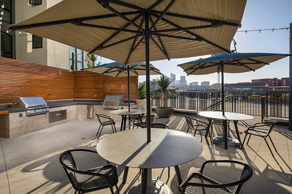 Grill area with modern picnic tables at Llewellyn Apartments' courtyard