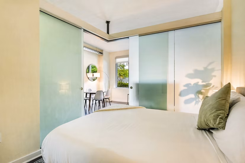 Modern bedroom featuring chic decor and large windows at DelRay Tower Apartments