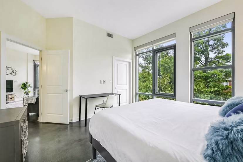 Modern bedroom with sleek furnishings and natural light at DelRay Tower Apartments