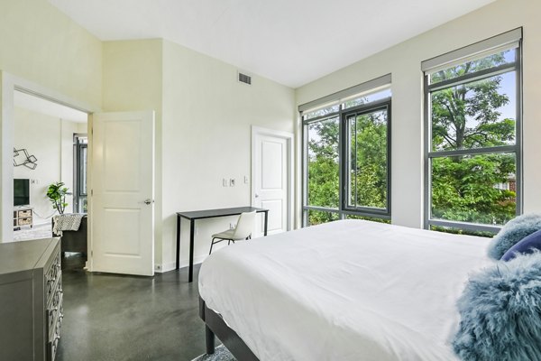 Modern bedroom with sleek furnishings and natural light at DelRay Tower Apartments
