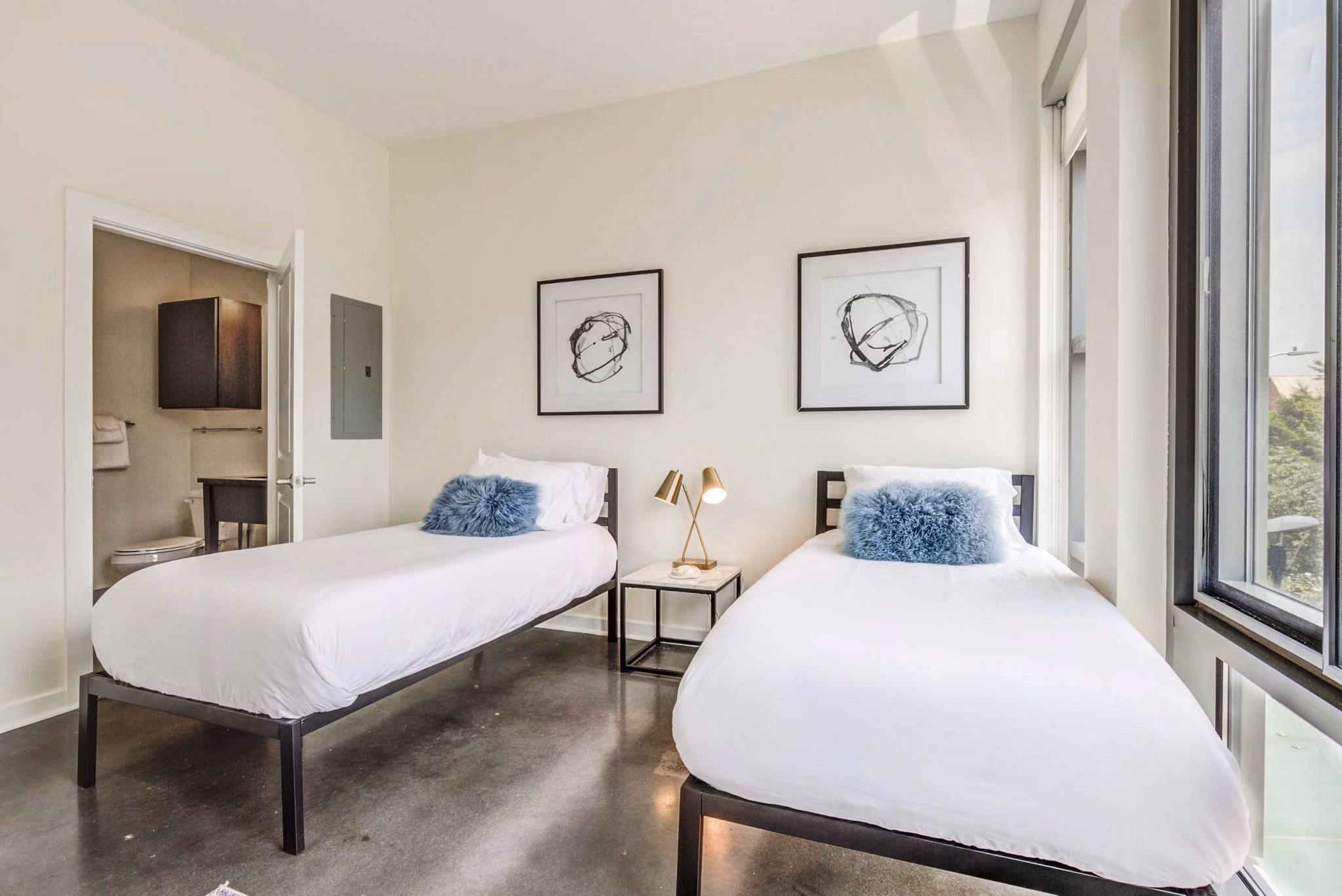 Modern bedroom with chic decor and ample sunlight in DelRay Tower Apartments