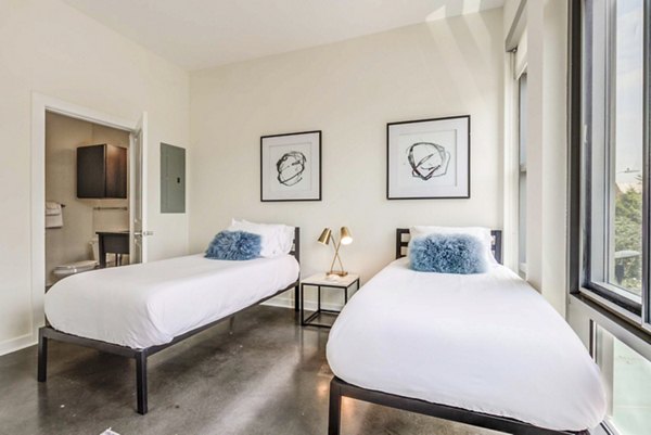 Modern bedroom with chic decor and ample sunlight in DelRay Tower Apartments