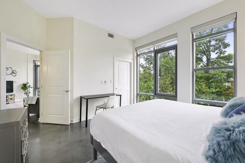 Cozy bedroom in DelRay Tower Apartments with modern furnishings and ample natural light