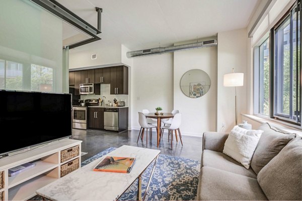 Spacious living room with modern decor and natural light at DelRay Tower Apartments