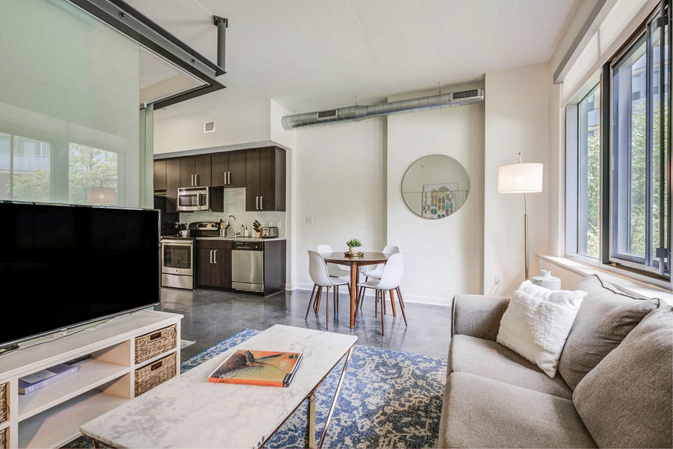 Spacious living room with modern decor and natural light at DelRay Tower Apartments