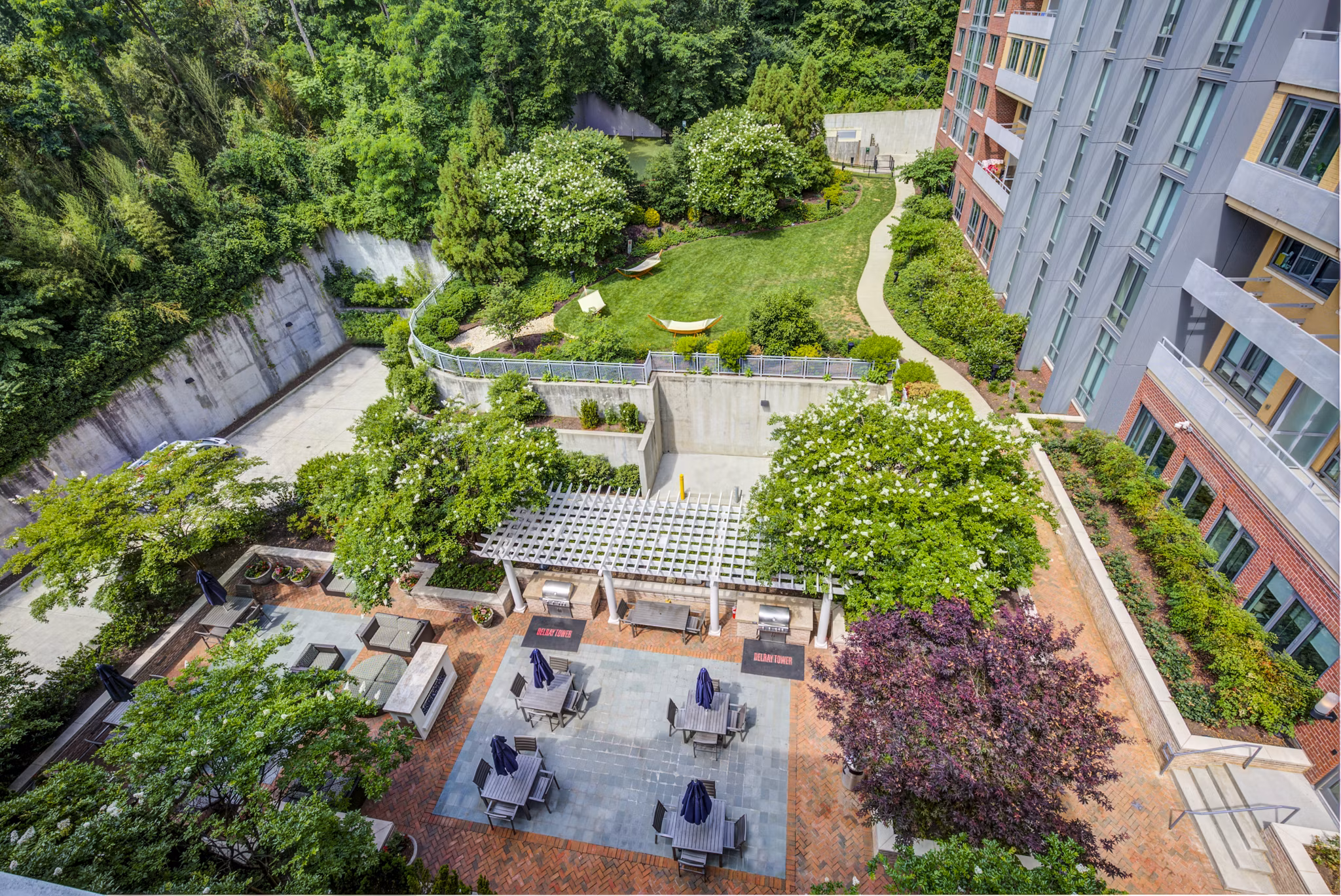 Scenic patio with lounge seating and garden view at DelRay Tower Apartments, luxury living in a peaceful community setting
