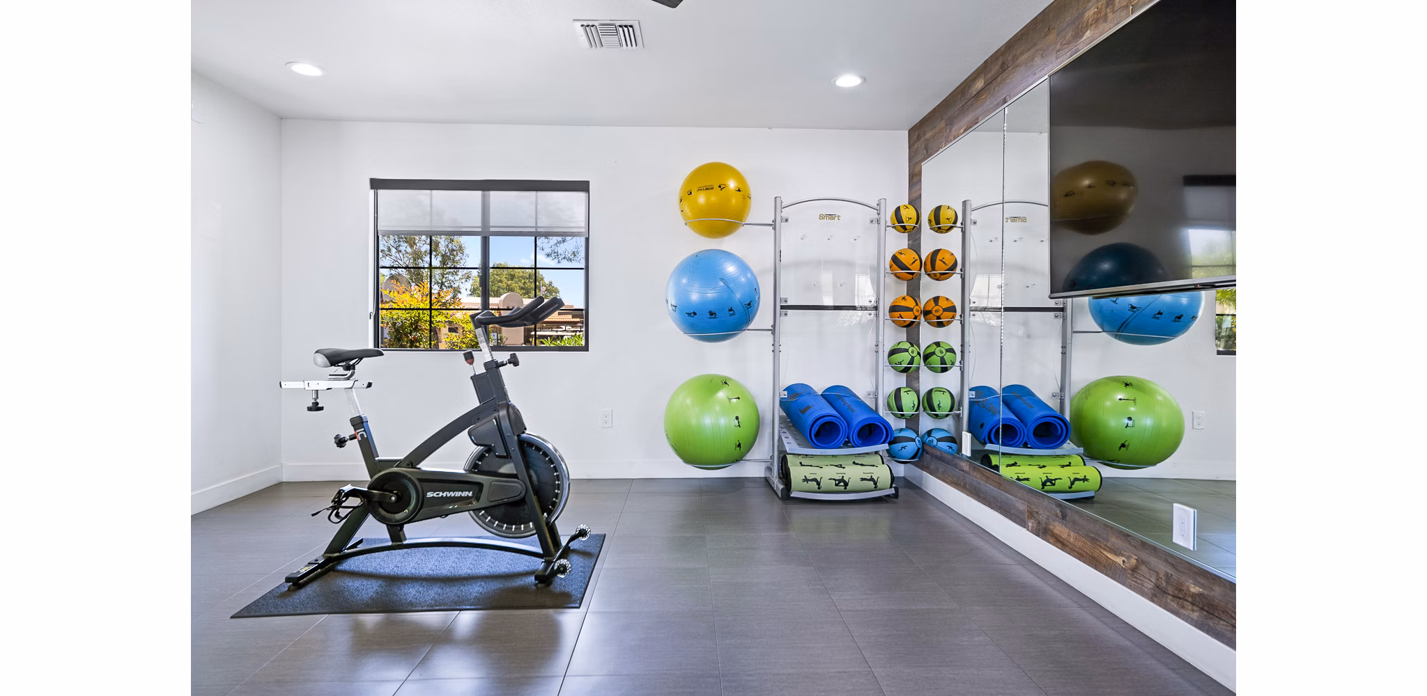 Yoga/spin studio with modern equipment at ENVii Apartments, promoting active lifestyle for residents