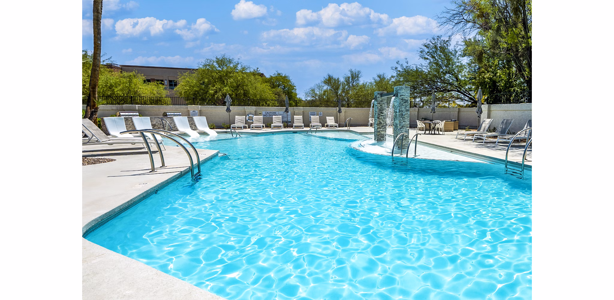 Expansive pool at ENVii Apartments with luxurious lounging areas for residents