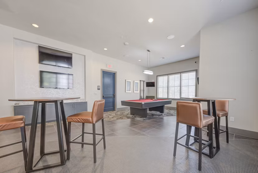 Game room featuring pool table and arcade games at Lone Oak Apartments, offering fun and relaxation for residents