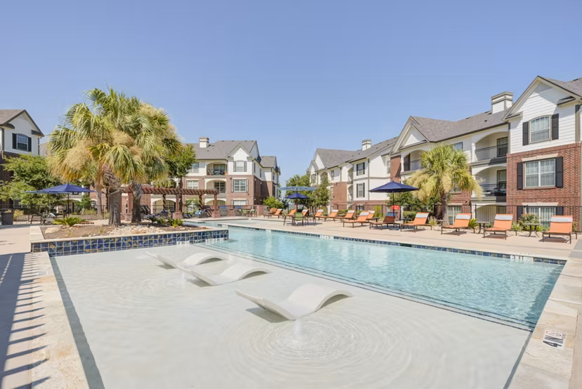 Sunlit outdoor pool with lounging area at Lone Oak Apartments, perfect for relaxation and leisure activities