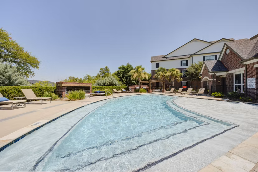 Resort-style pool with palm trees at Lone Oak Apartments, offering luxury living spaces and amenities