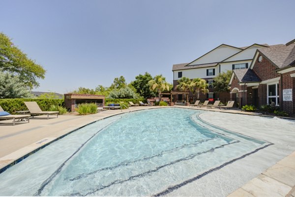 Resort-style pool with palm trees at Lone Oak Apartments, offering luxury living spaces and amenities