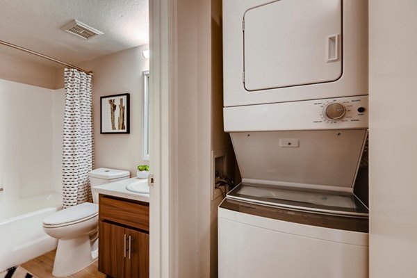 Laundry room with modern machines at Espiral Apartments, luxury living in Greystar's upscale community