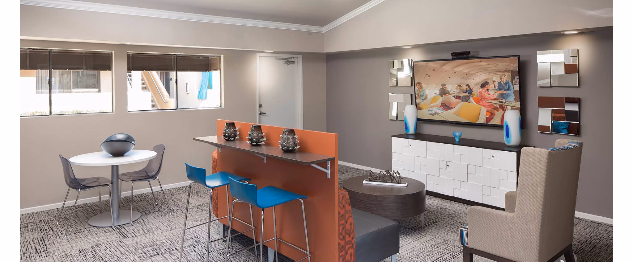 Clubhouse featuring modern design and ample seating at The Highlands at Grand Terrace Apartments
