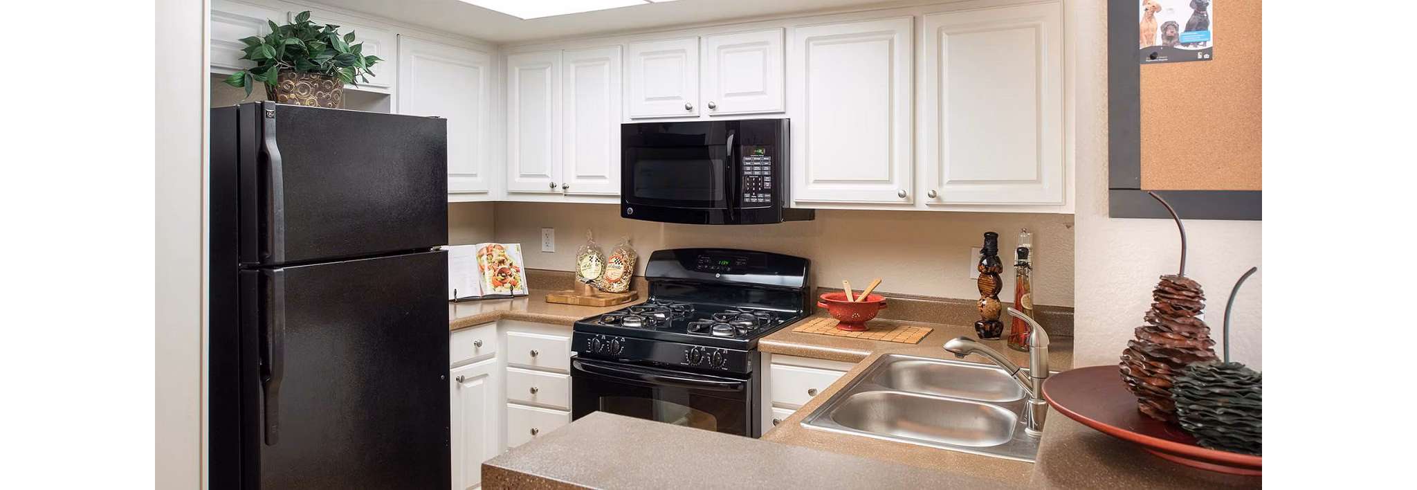 Modern kitchen with stainless steel appliances at The Highlands at Grand Terrace Apartments