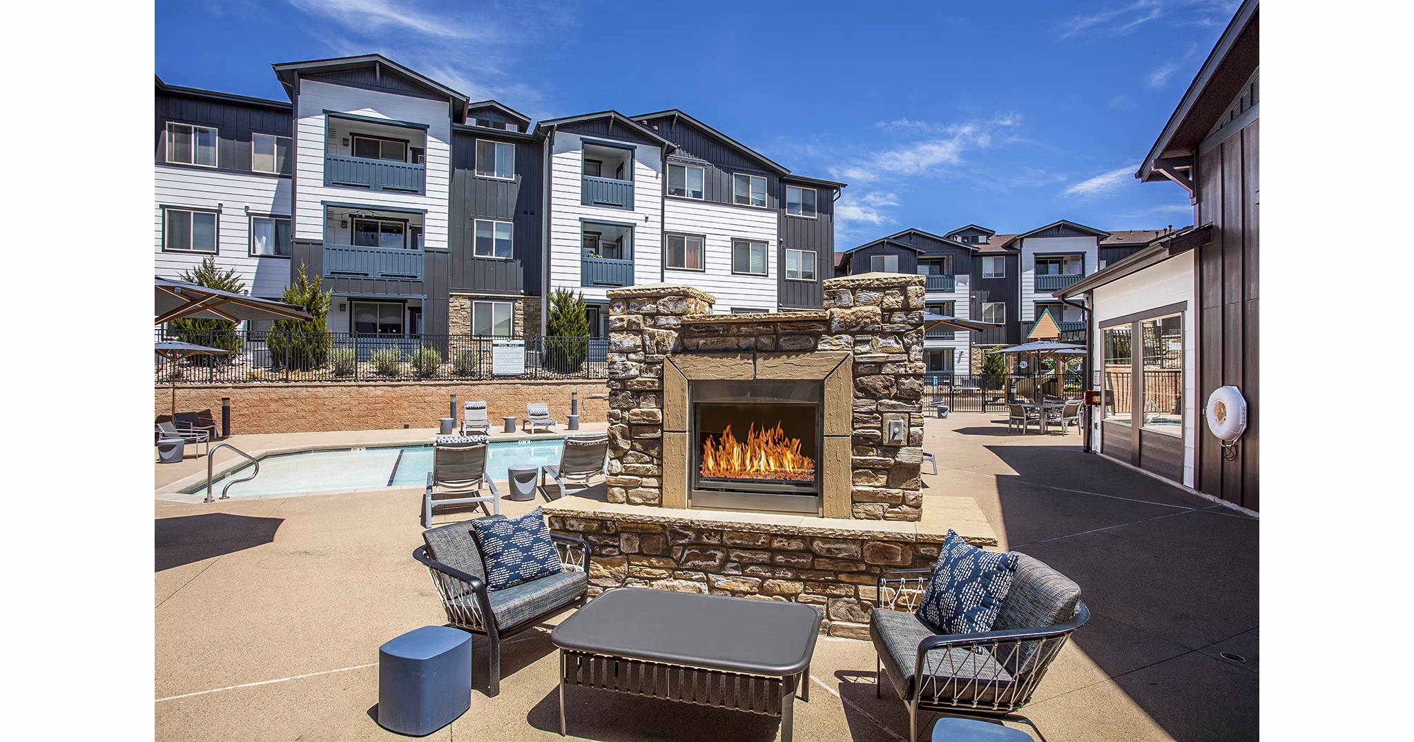 Fire pit patio with cozy seating at Rockrimmon Apartments, nestled in natural surroundings for relaxed outdoor living experience