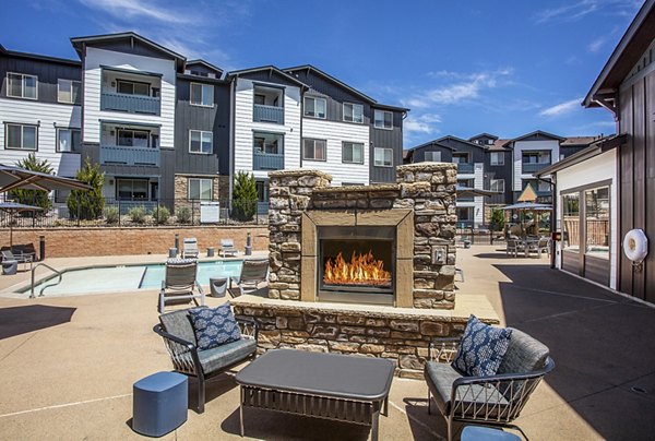 Fire pit patio with cozy seating at Rockrimmon Apartments, nestled in natural surroundings for relaxed outdoor living experience