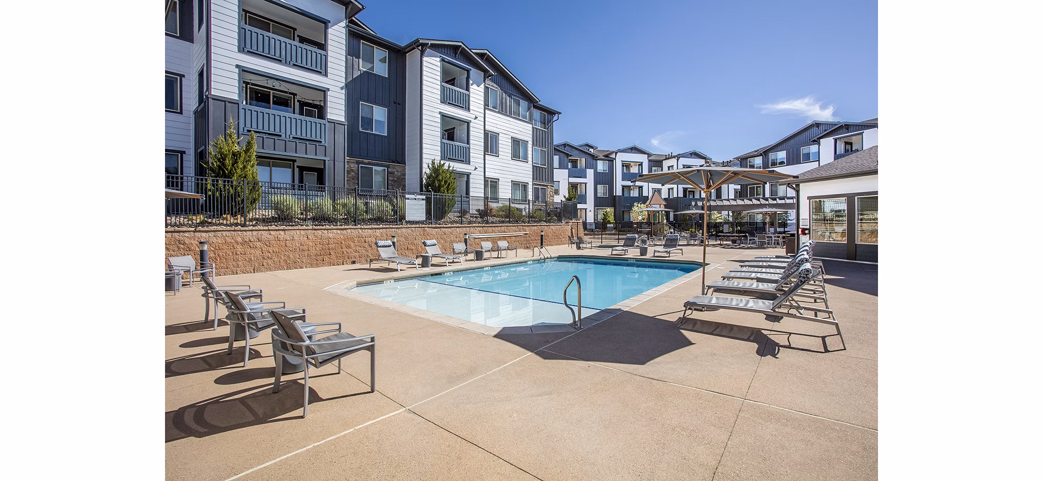 Serene outdoor pool with lounge chairs at Rockrimmon Apartments for relaxation and recreation