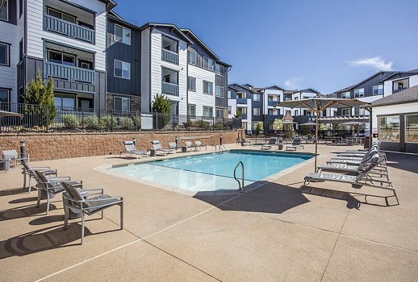 Serene outdoor pool with lounge chairs at Rockrimmon Apartments for relaxation and recreation