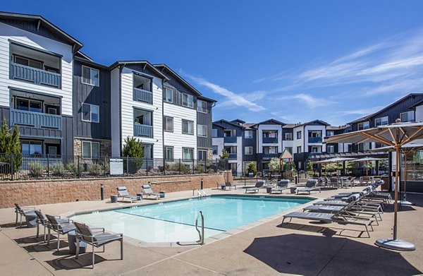 Outdoor swimming pool with lounge chairs at luxury apartments in a scenic setting