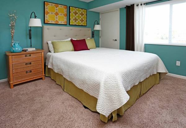 Cozy bedroom with plush bedding in Avana Addison Apartments