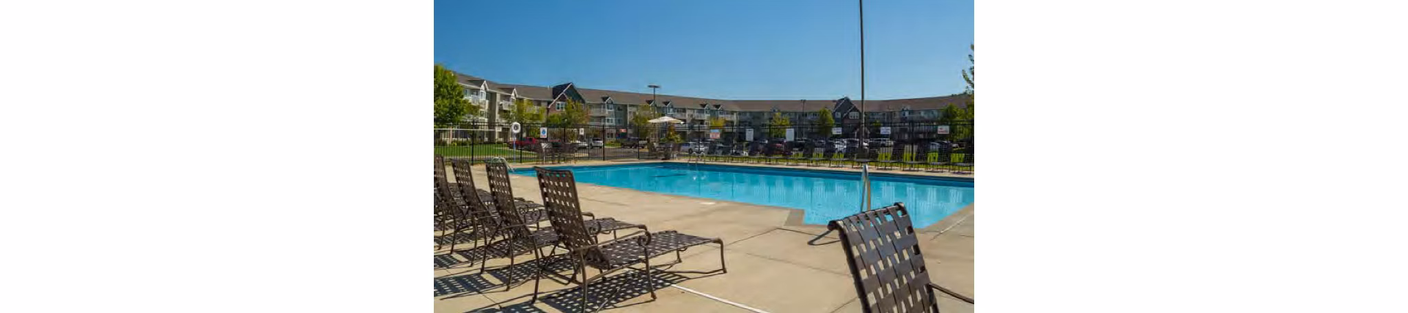 Resort-style pool with lush landscaping at Avana Addison Apartments in Dallas, offering a luxury relaxation experience for residents