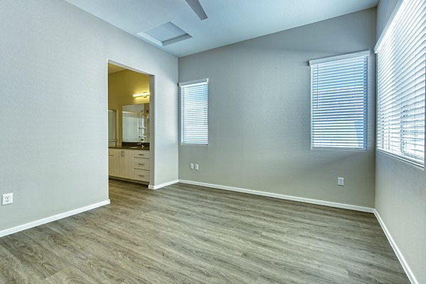 Bedroom with modern decor and large window at Abode at Litchfield Park Apartments, offering luxurious living in a serene environment