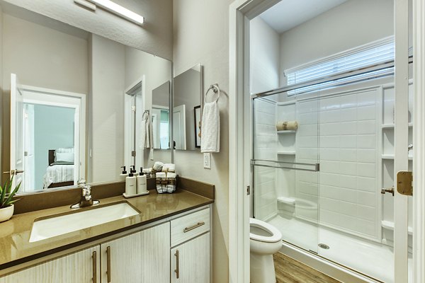 Bathroom with sleek fixtures and marble countertops in Abode at Litchfield Park Apartments
