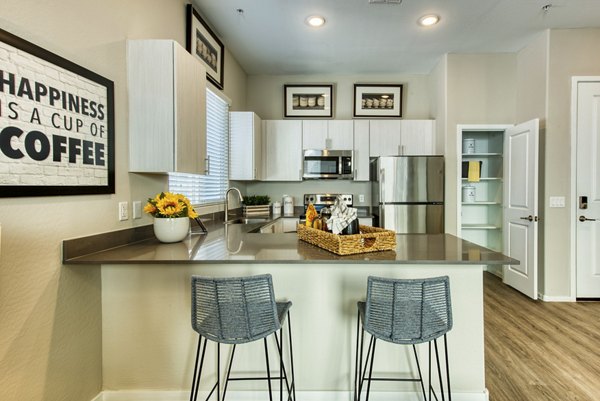 Modern kitchen with stainless steel appliances and island at Abode at Litchfield Park luxury apartments