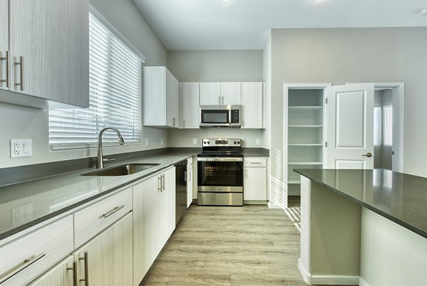 Kitchen detailing modern appliances and granite countertops in Abode at Litchfield Park Apartments Luxury living spaces by Greystar