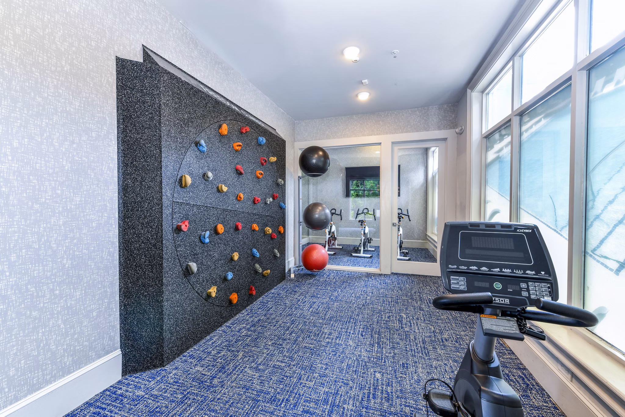 Indoor climbing wall at Avana Cheshire Bridge Apartments fitness center: Modern facility for active lifestyles in luxury living environment