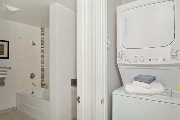 Laundry room with modern washers and dryers at 38 Dolores Apartments