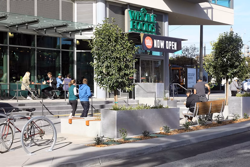 Modern streetscape view near Whole Foods in a residential area, highlighting vibrant city living at Greystar luxury apartments